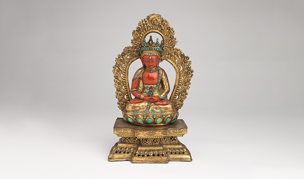 a gold, coral, and turquoise buddha figure