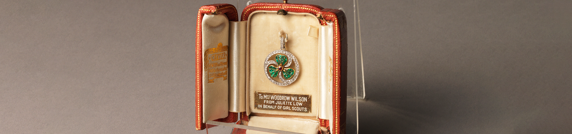  a diamond, ruby, and emerald encrusted thank you badge in a leather display case 