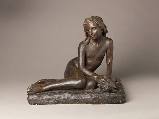 a plaster painted bronze statue of a young girl petting a tortoise