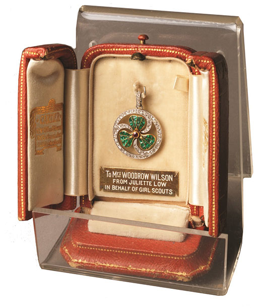 a diamond, ruby, and emerald encrusted thank you badge in a leather display case