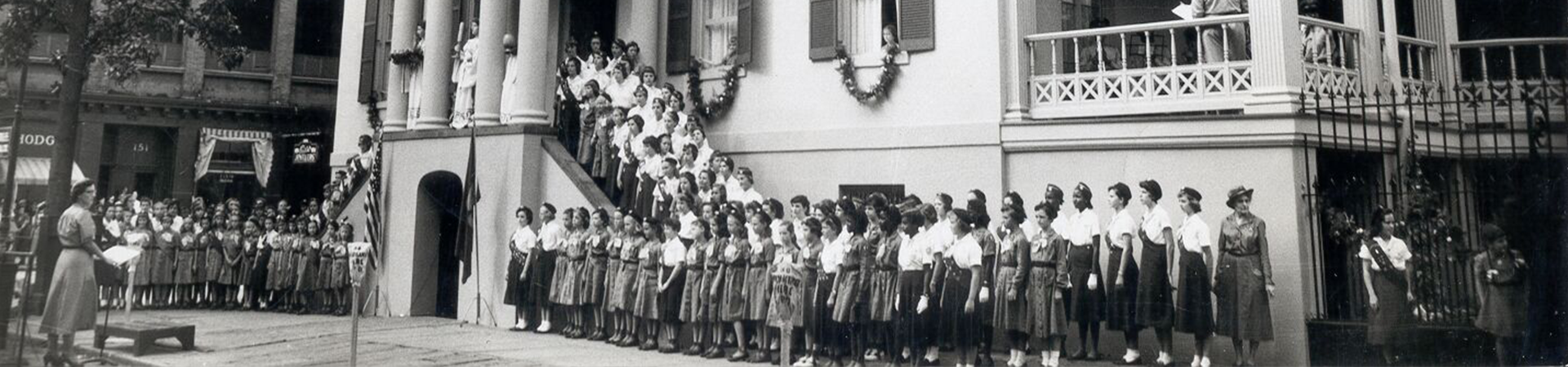  Girl Scouts and leaders gather around the front porch for a traditional "Blessing the House" ceremony, part of the Juliette Gordon Low Birthplace's official dedication in October 19, 1956. 