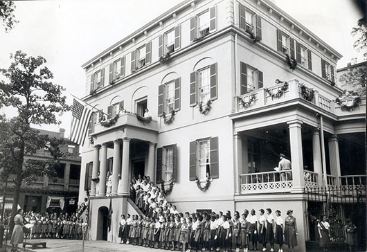 the birthplace with many girl scouts around the house celebrating