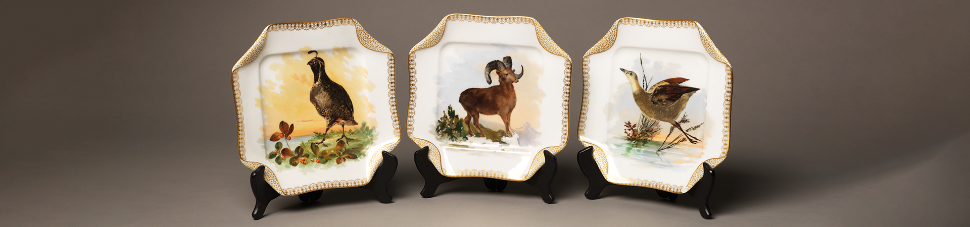  three plates with game paintings in the center and gold trim  