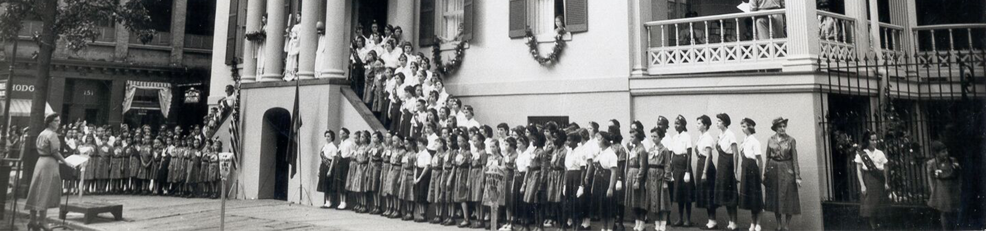  the birthplace with many girl scouts around the house celebrating 