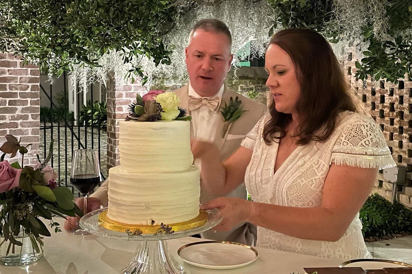 A cake being cut as part of a wedding reception in the garden at the Juliette Gordon Low Birthplace.