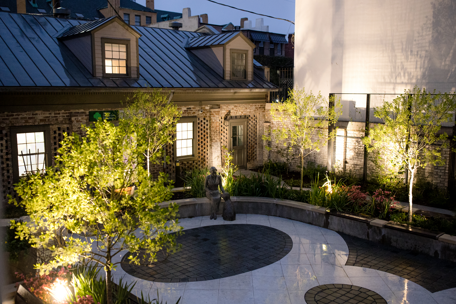 The garden at The Juliette Gordon Low Birthplace in the evening with lighting throughout.