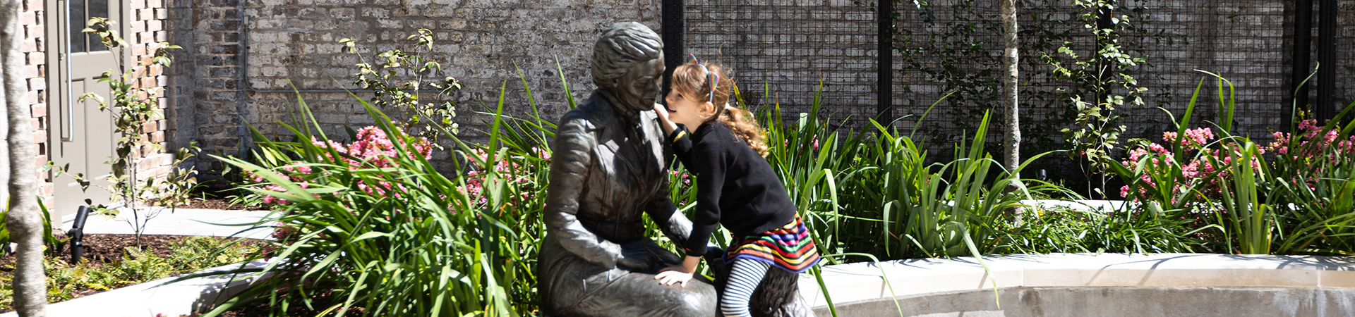  a young girl leaning into a statue of juliette gordon low 